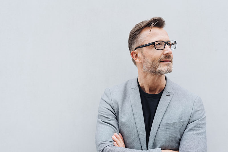 Unternehmensberatung Hösterey GbR - Unternehmenskultur und Leitbildentwicklung (Mann mit Brille und grauem Anzug)